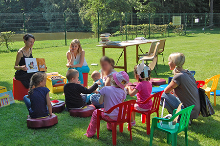 Atelier lecture avec les enfants dans le parc, ils sont tous heureux d'écouter