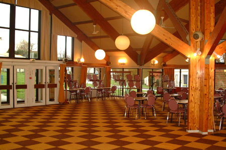 lampes de forme ovale qui éclairent une salle pleine de tables et de chaises sur une sol de carreaux