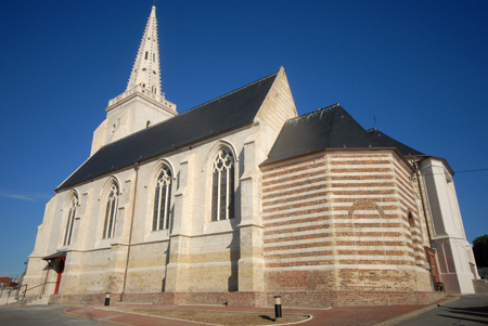 Grande église avec des murs blancs, des vitraux et une toiture noirs