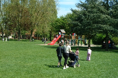 groupe de personnes avec une poussette se promenne dans le parc